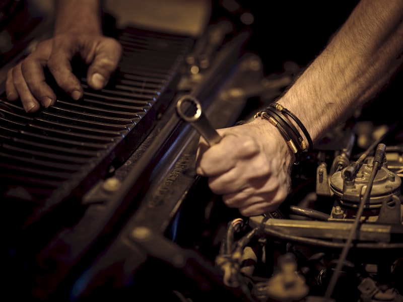 Hands using a lug wrench to loosen lug nuts on a wheel