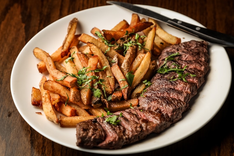 Steak searing in a cast iron skillet with a golden-brown crust forming